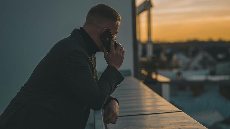 A man on a phone call at dusk