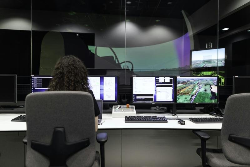 An operator at a monitoring desk with several screens